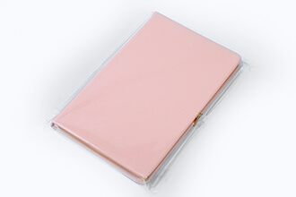 a pink notebook packaged with pp bag