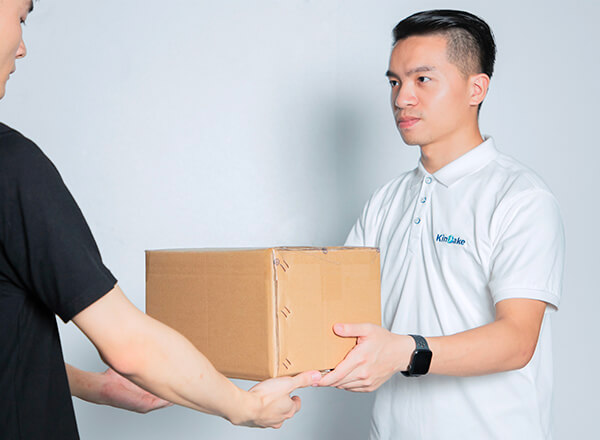 an employee in Kinbake uniform is delivering a box to another person