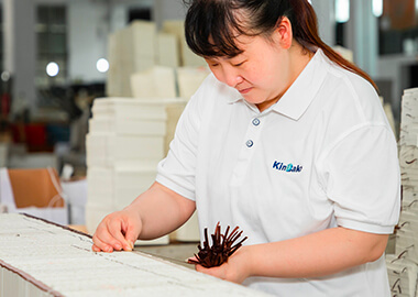a female worker in Kinbake uniform gluing ribbons into a notebook