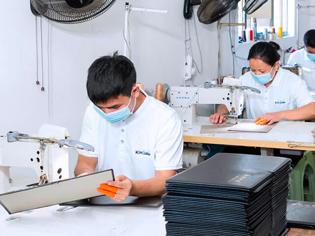 a team of sewing workers are sewing notebooks